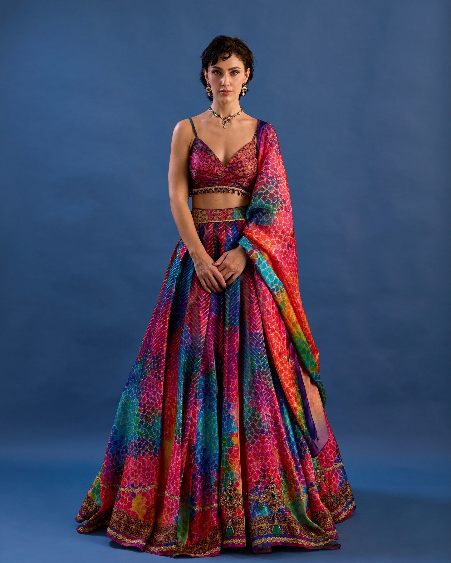 Woman wearing a colorful traditional outfit against a blue background