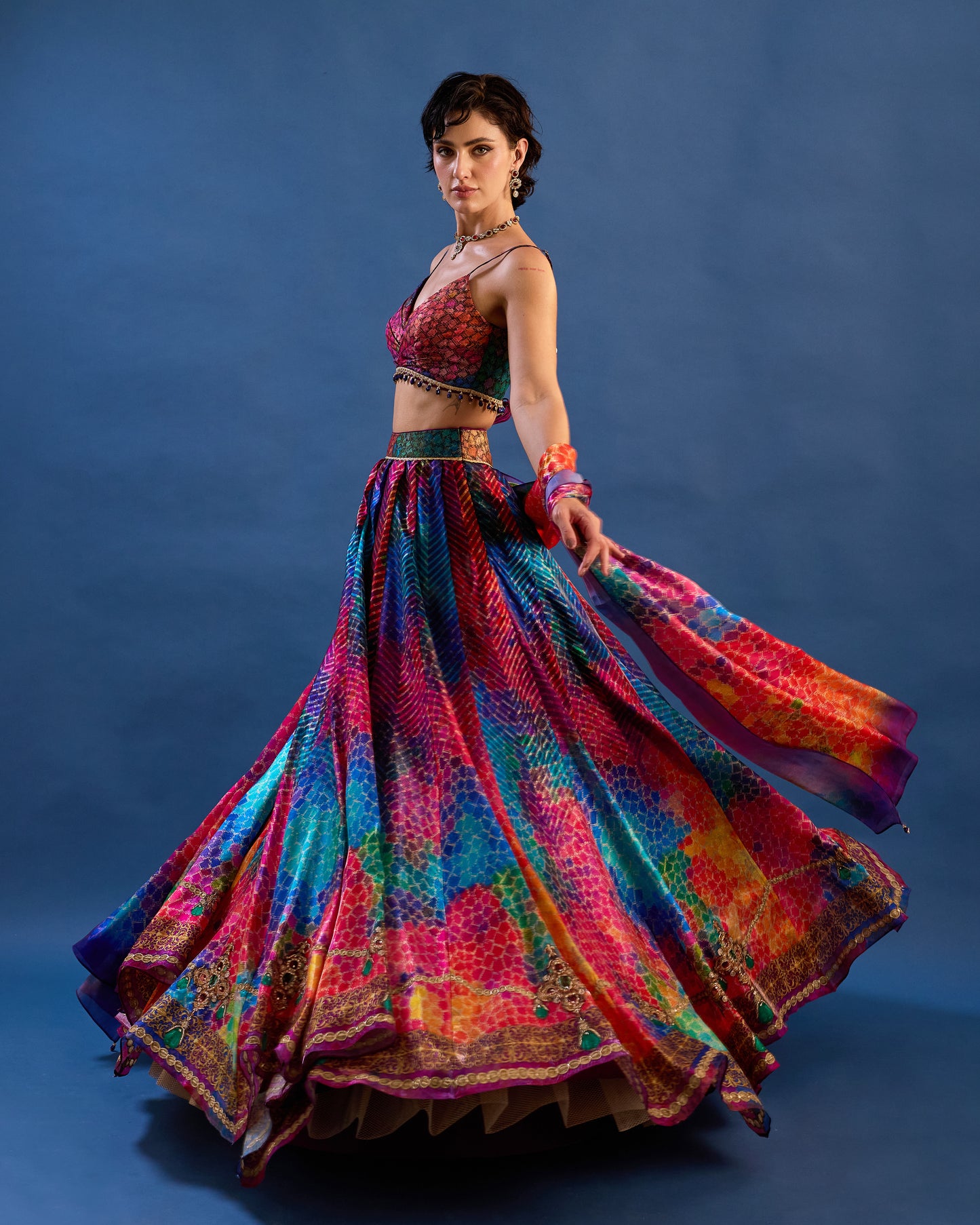 Woman wearing a colorful traditional outfit against a blue background