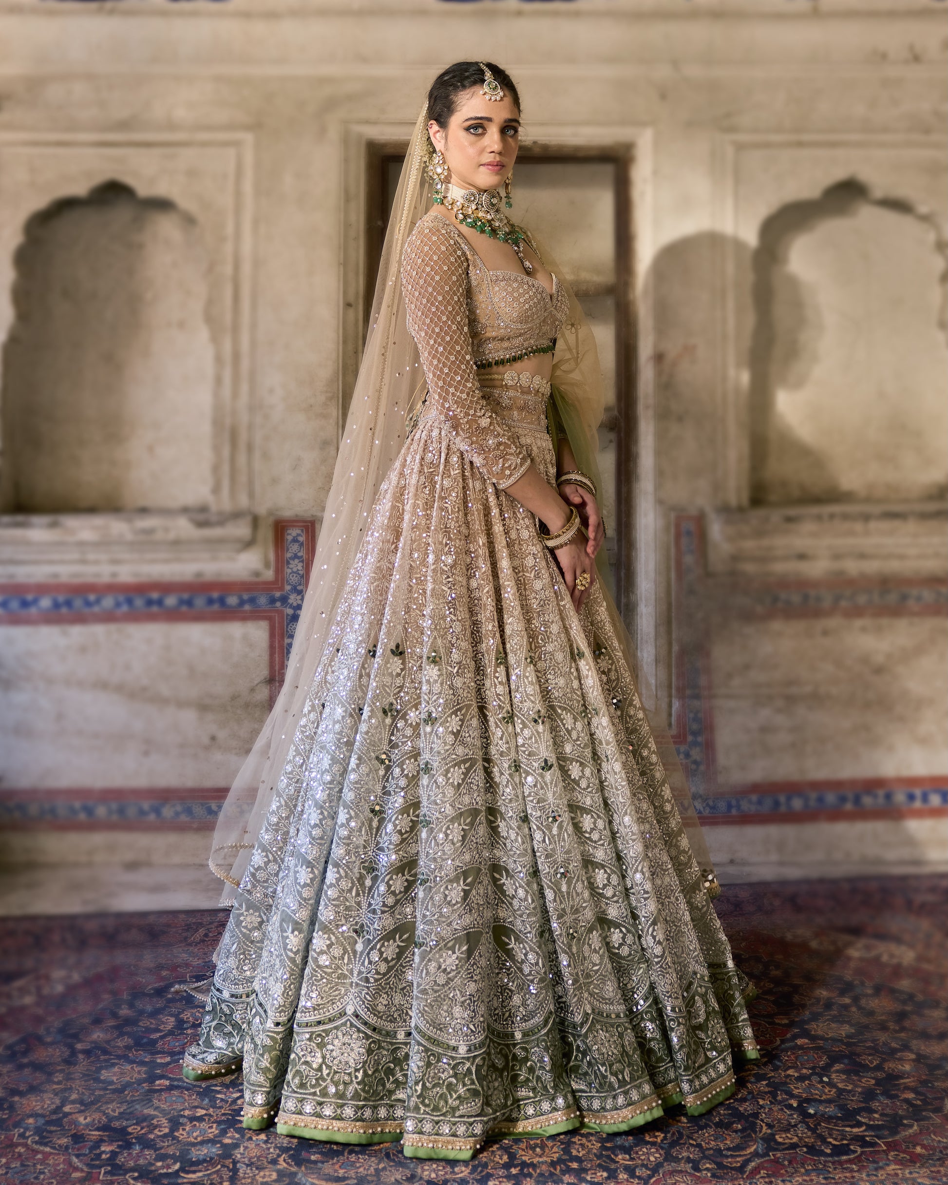 Side profile of Nighat lehenga styled with pearl jewellery and bun hairstyle