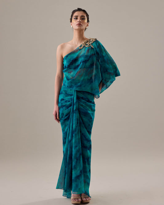 Woman wearing a teal one-shoulder dress with a plain background