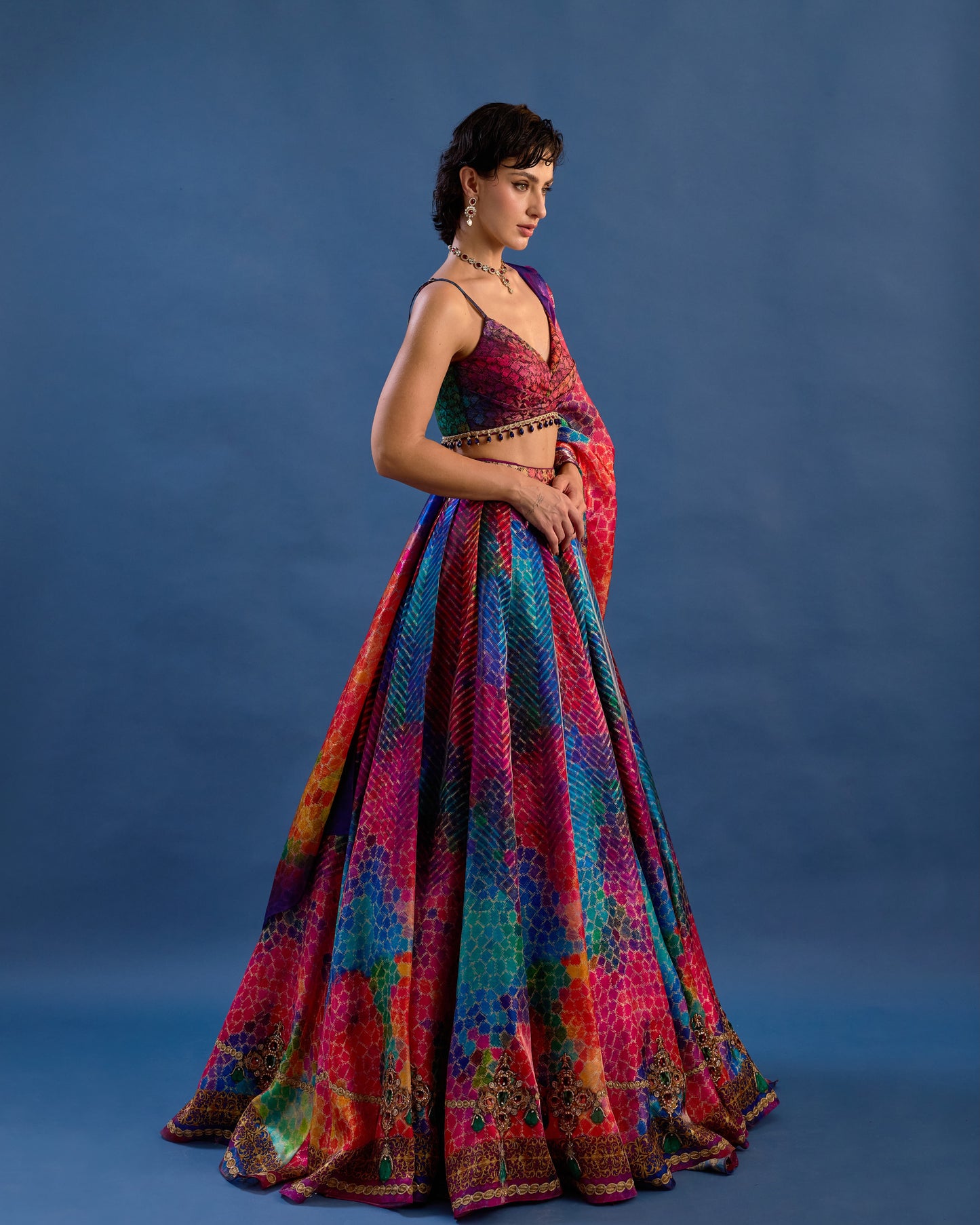 Woman wearing a colorful traditional outfit against a blue background