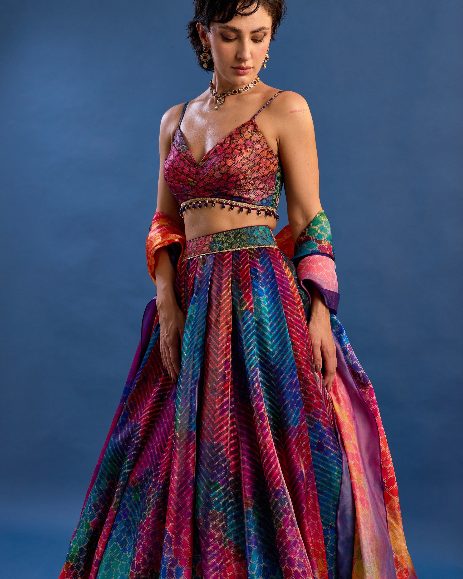 Woman wearing a colorful traditional outfit against a blue background