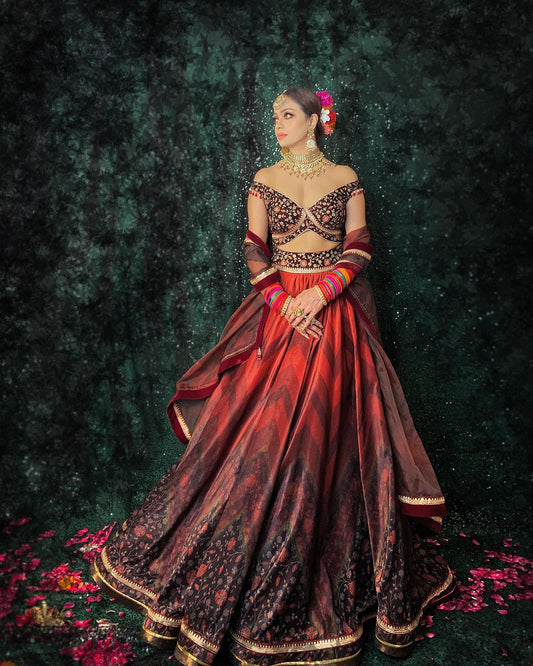 Velvet lehenga with chevrons of shades of red, off shoulder blouse and organza dupatta