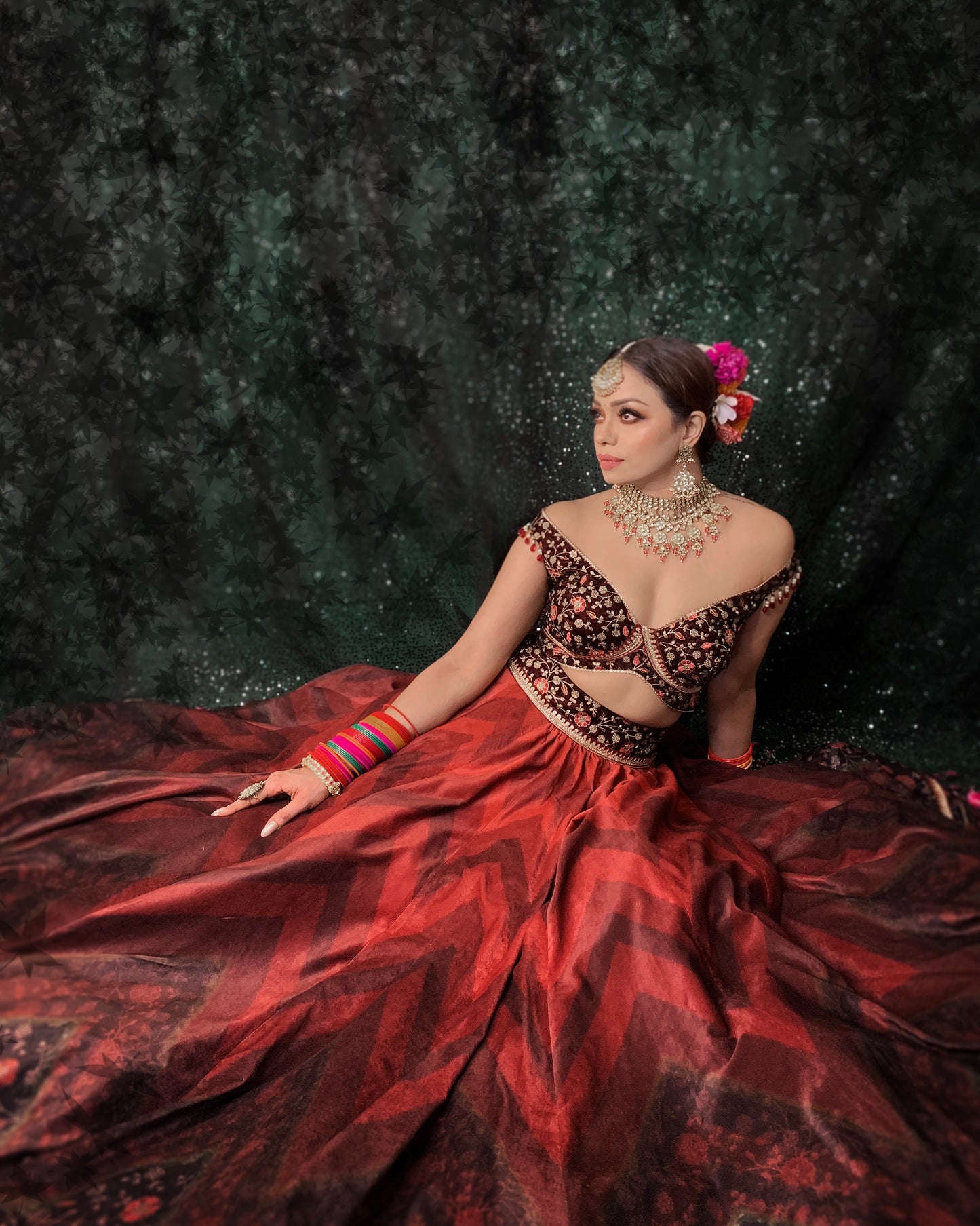 Velvet lehenga with chevrons of shades of red, off shoulder blouse and organza dupatta